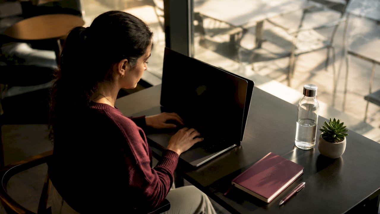 Student using laptop with privacy screen in library