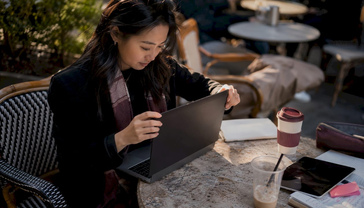 Woman applying privacy screen on MacBook laptop