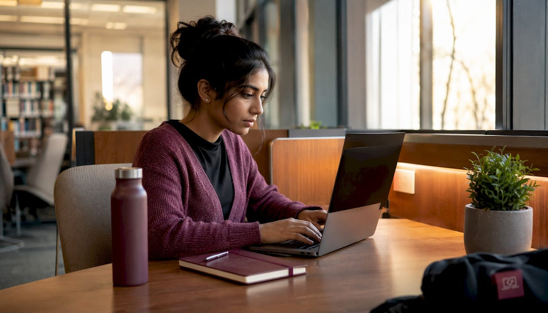 Woman using laptop with privacy filter in coworking space