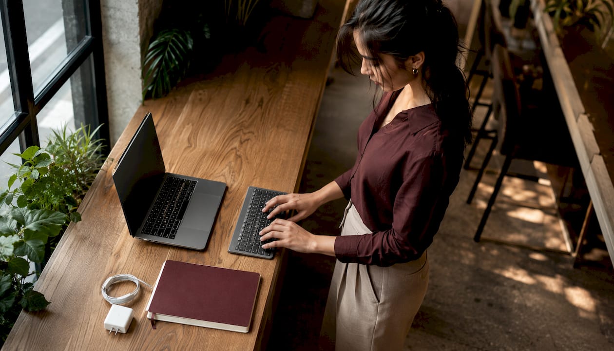 Woman using minimal MacBook setup at café