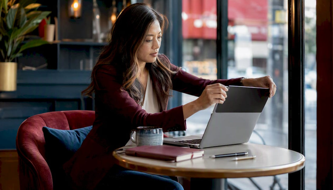 Woman attaching privacy screen to MacBook at hot desk